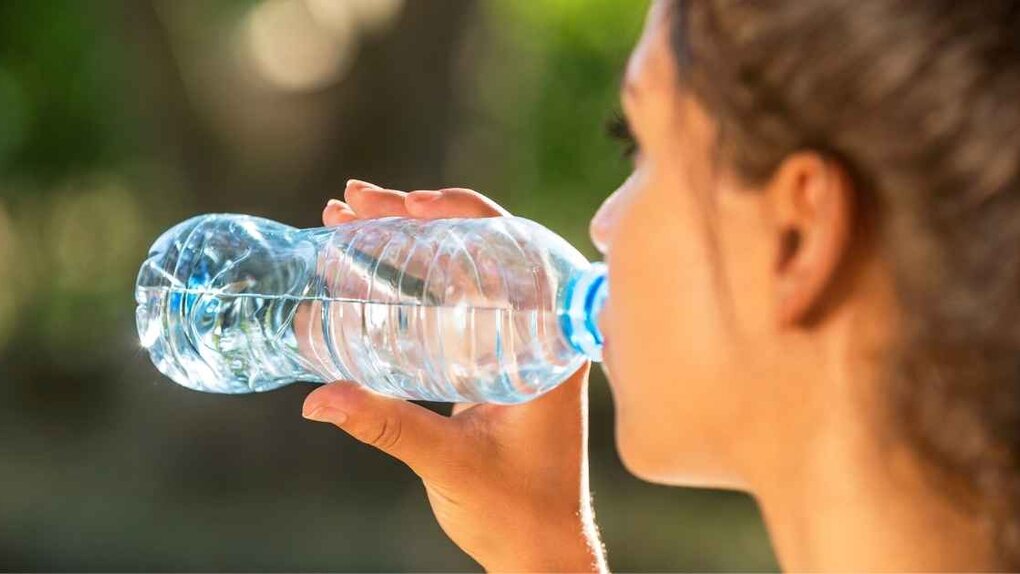 Eine Frau trinkt Wasser aus einer Flasche